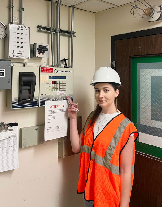 Engineer Demonstrating Control Panel in Industrial Setting